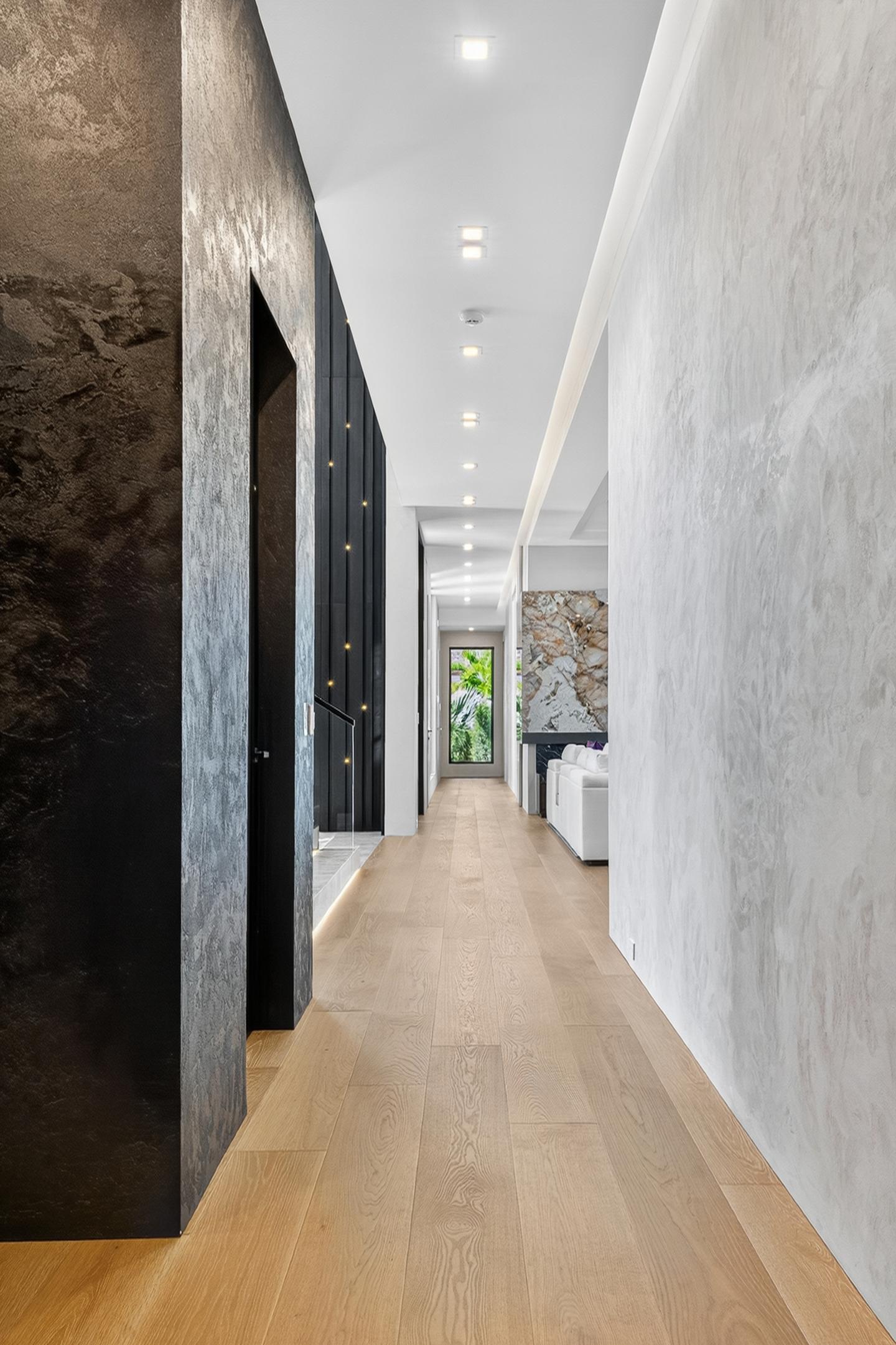Main corridor with marble walls and view to marble living room feature wall