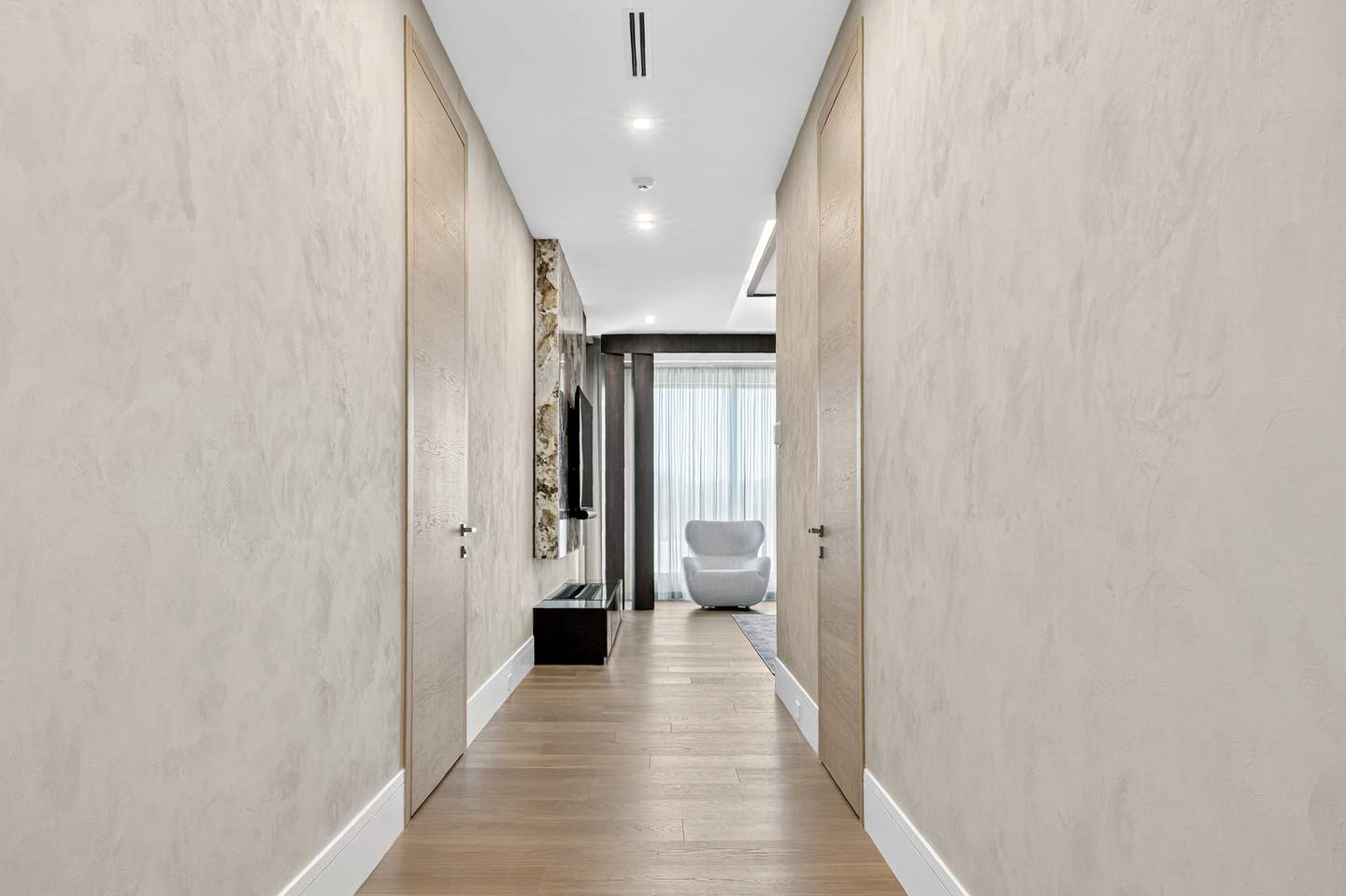 Upper corridor with light plaster walls and oak pocket doors