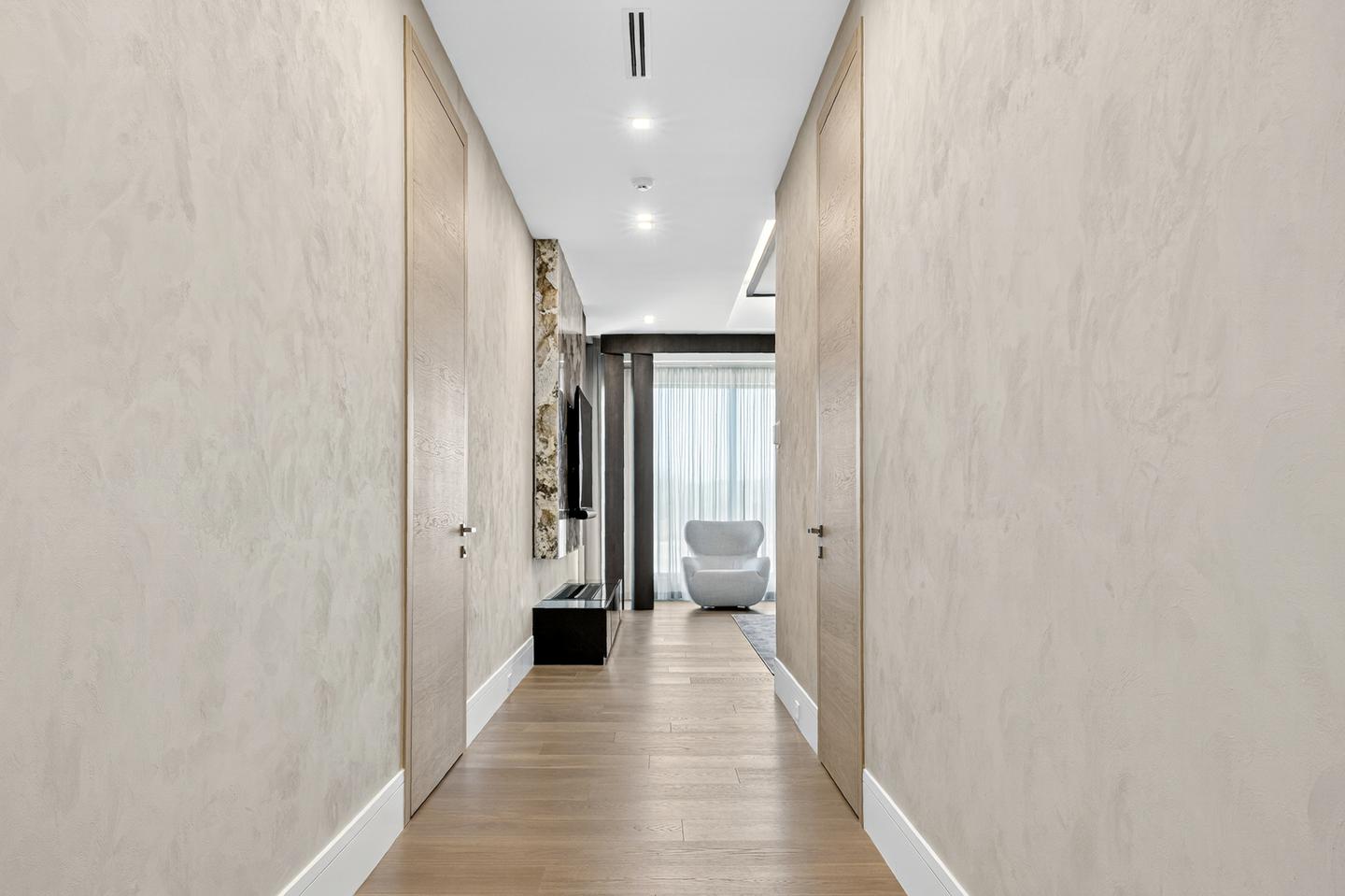 Upper corridor with light plaster walls and oak pocket doors