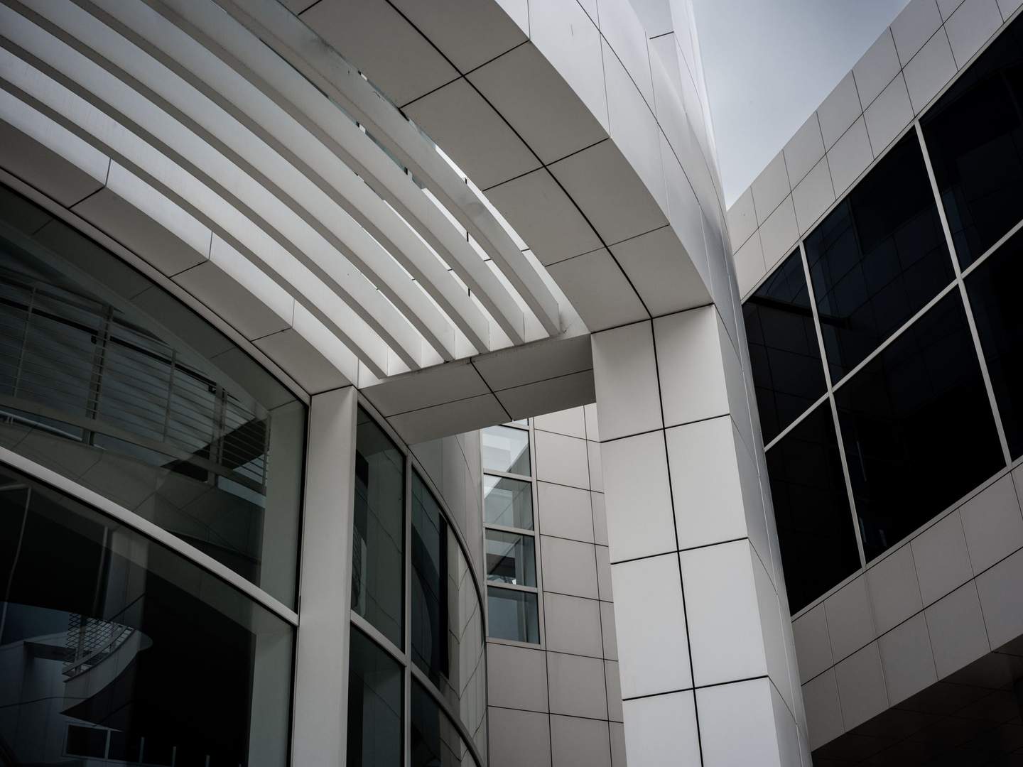 Getty Center curved aluminum louver system on gallery facade viewed from below, sunscreening elements reading as pure ornament at close range