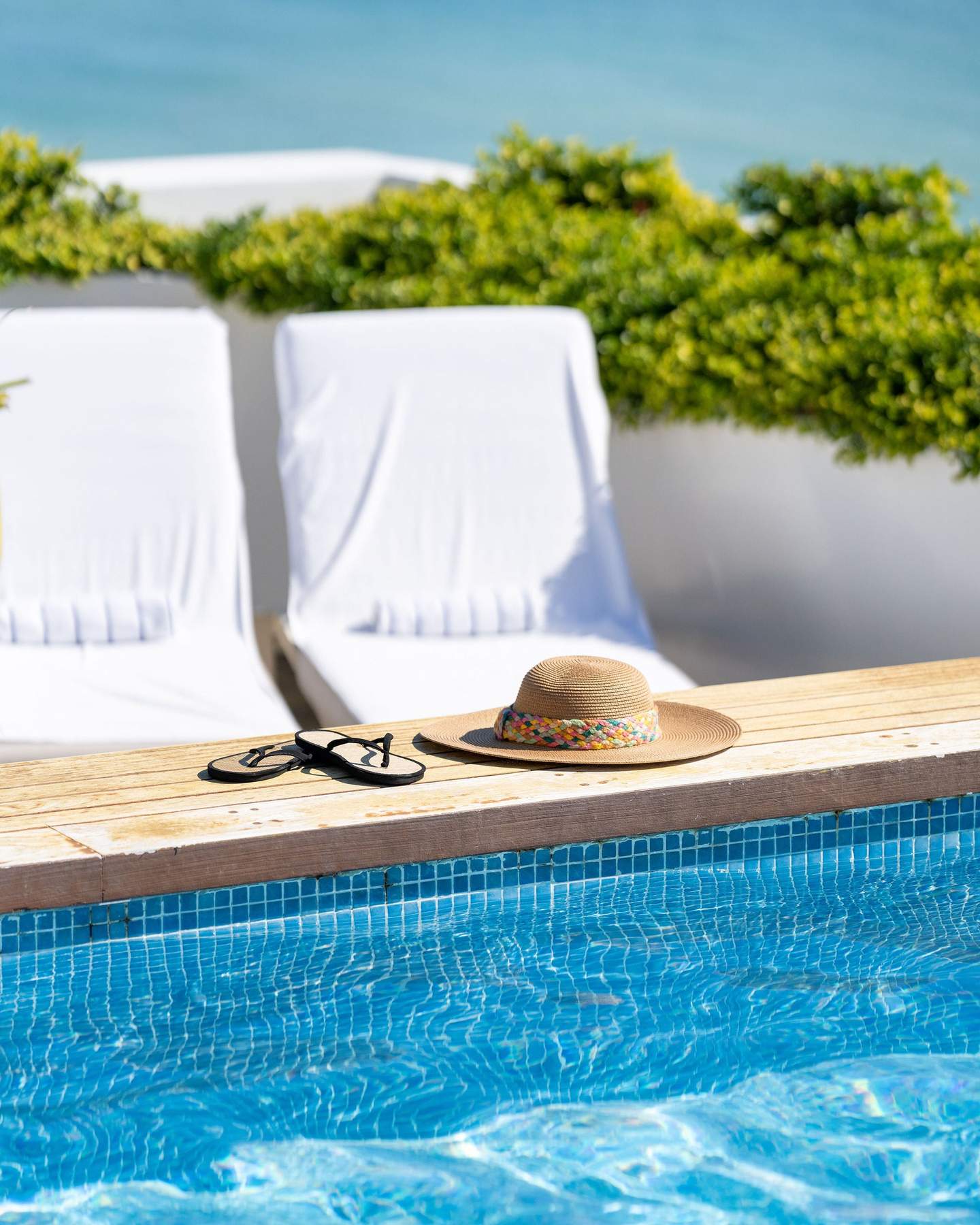 Sun hat and sandals at rooftop pool