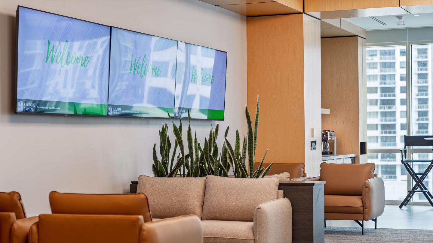Builders Capital welcome lounge with three-panel video wall