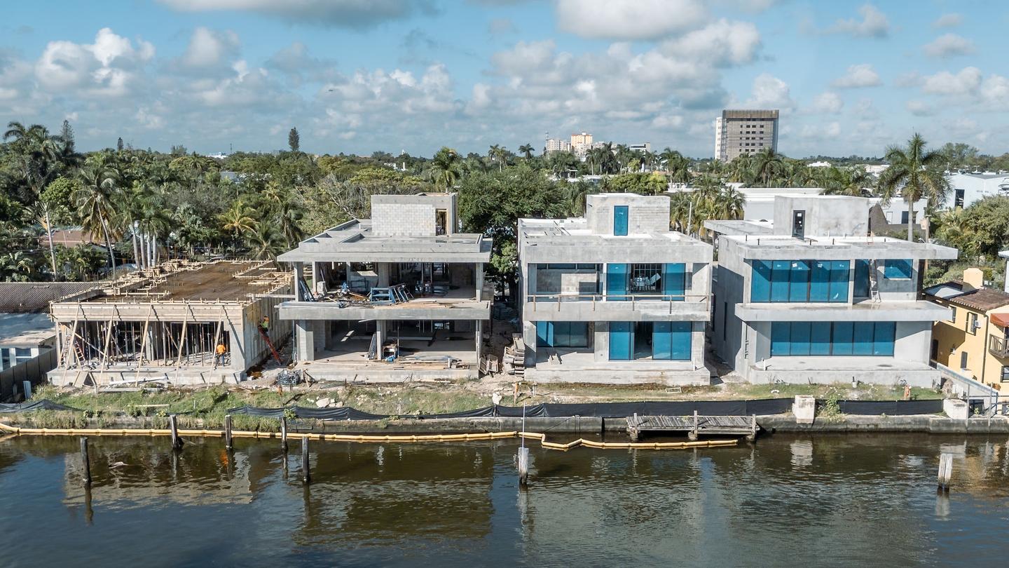 Aerial view — dual-structure waterfront site from across the canal