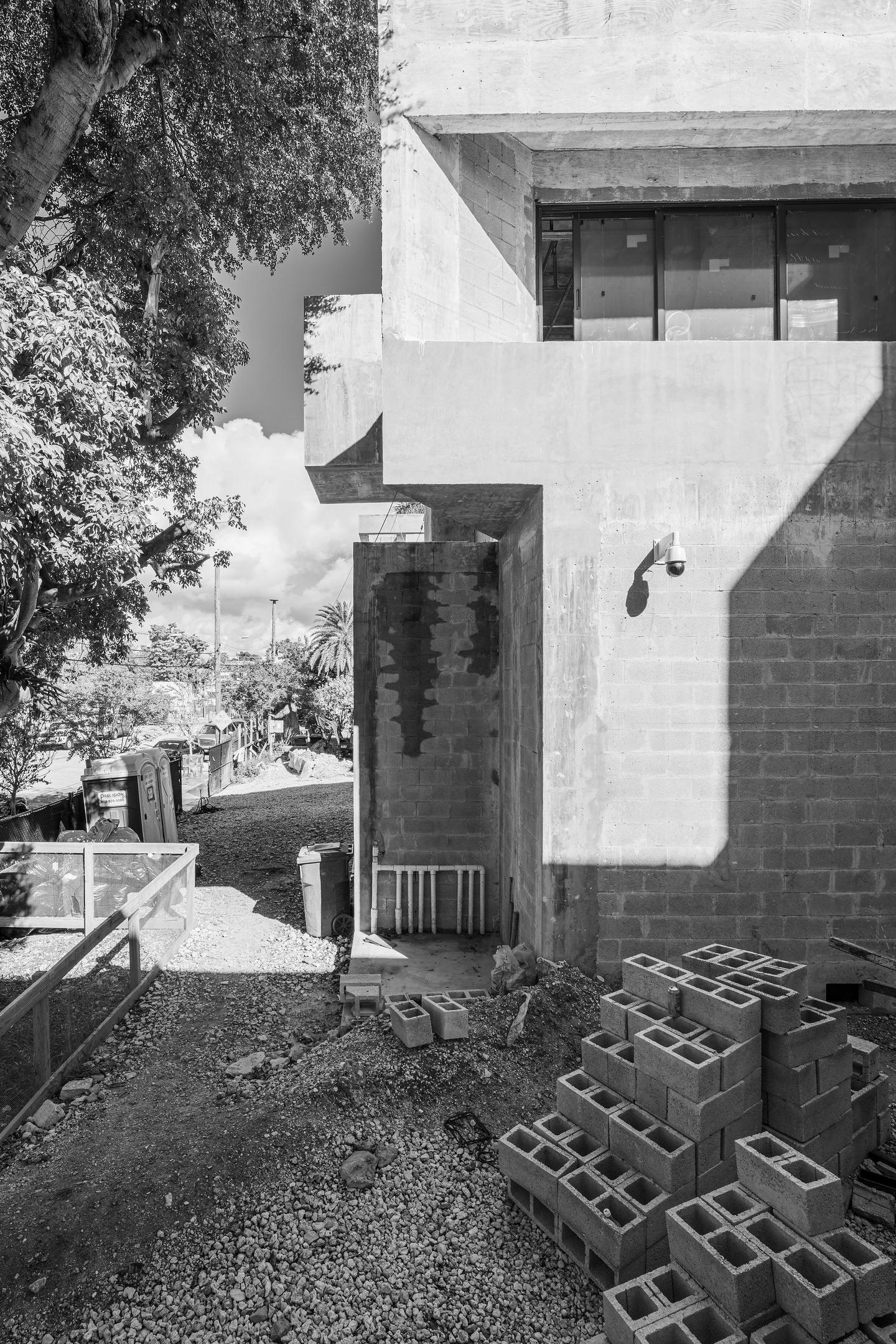 Side elevation detail — cinder block construction and window openings in black and white