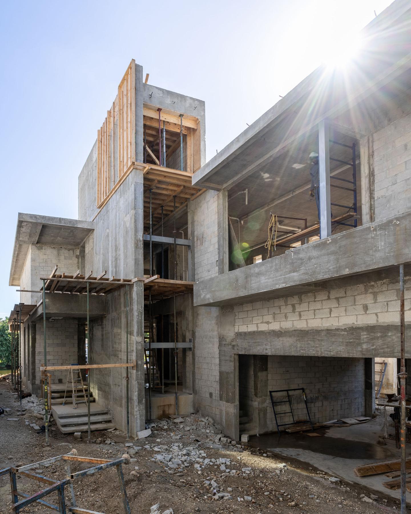 Rear elevation under construction — scaffolding, upper-level framing, and open volumes
