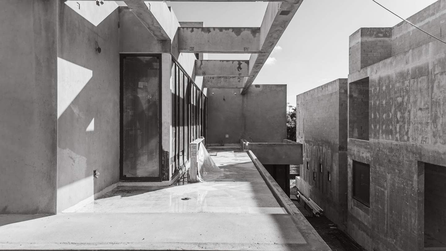 Upper terrace level — concrete volumes and structural bays in black and white