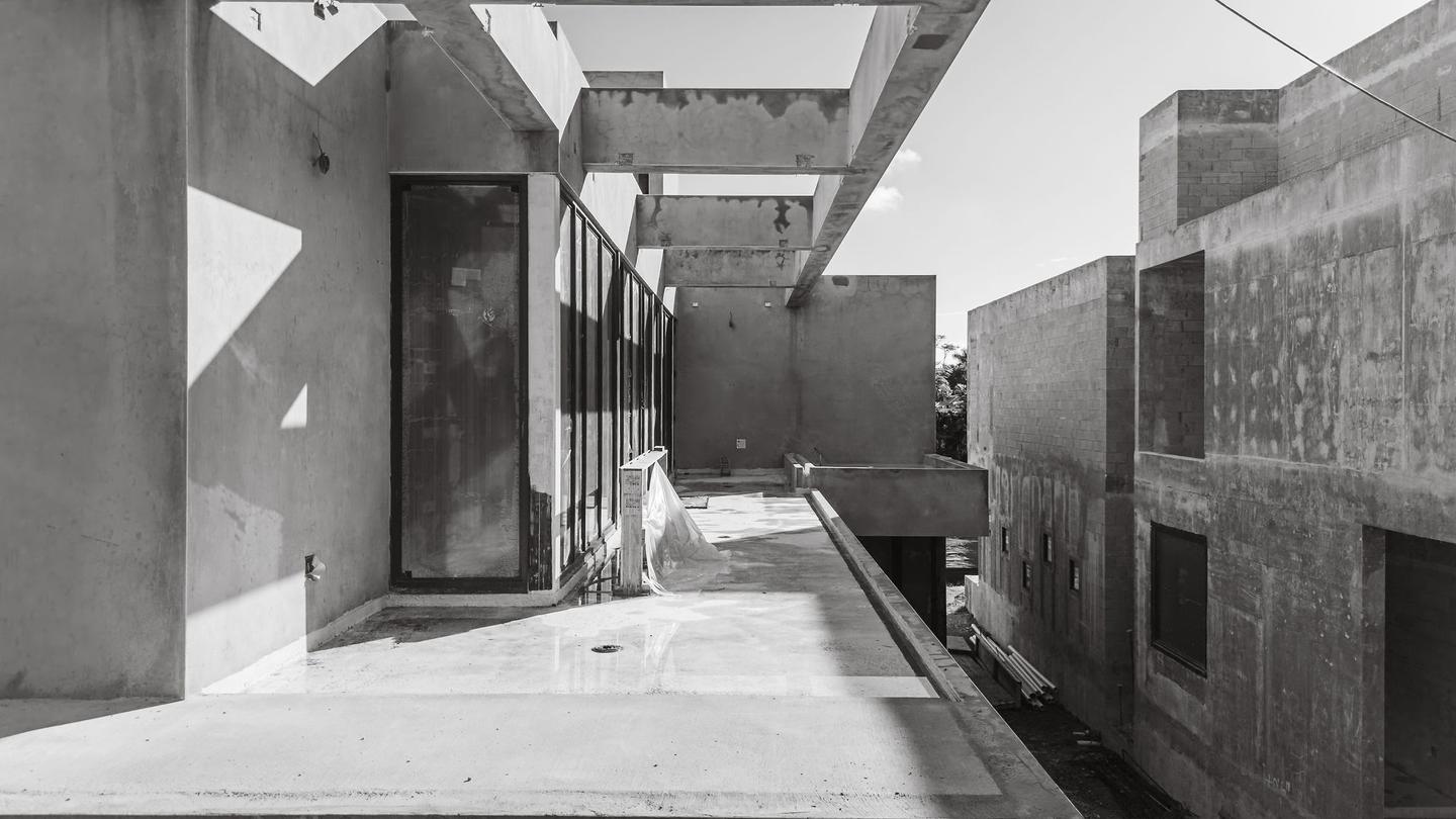 Upper terrace level — concrete volumes and structural bays in black and white